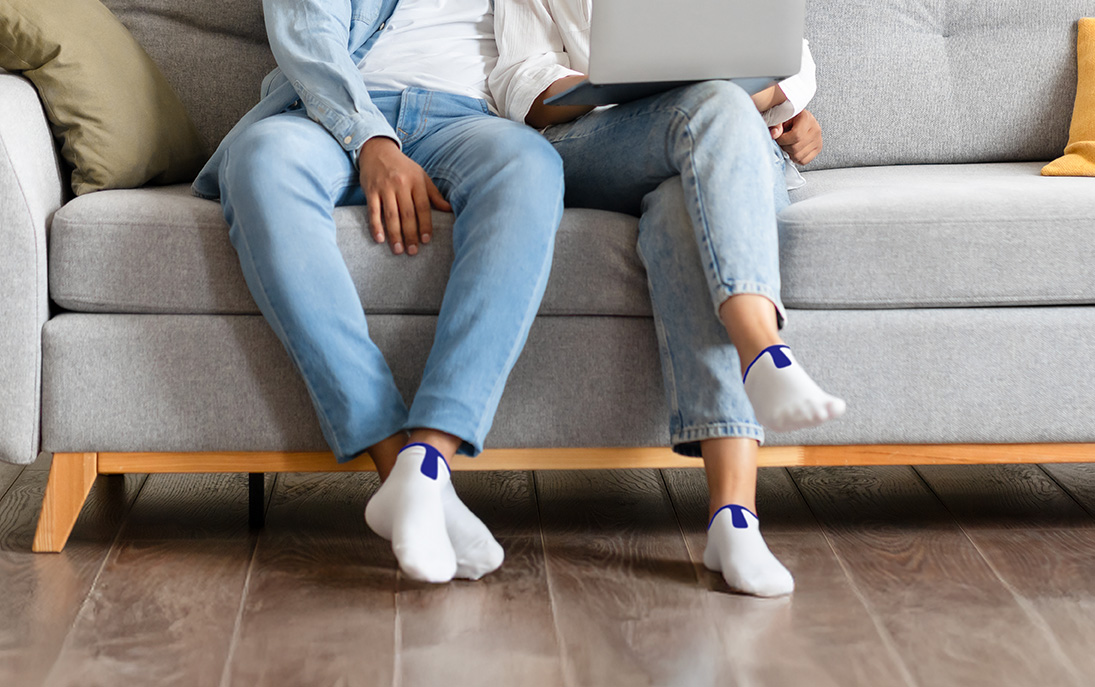 couple sitting on couch wearing product