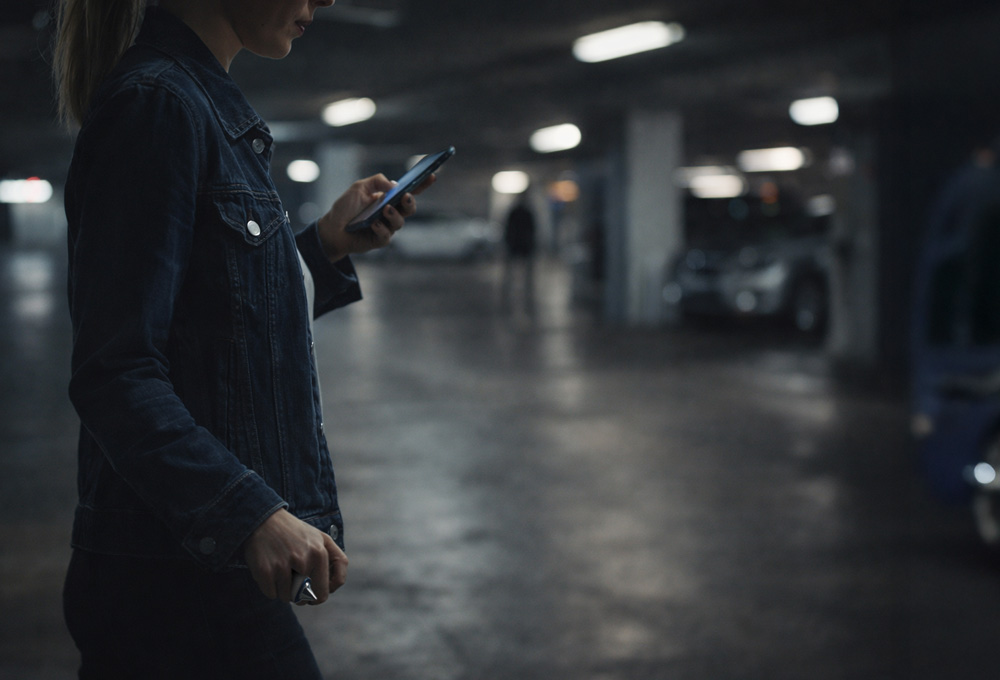 woman holding product in dark parking garage