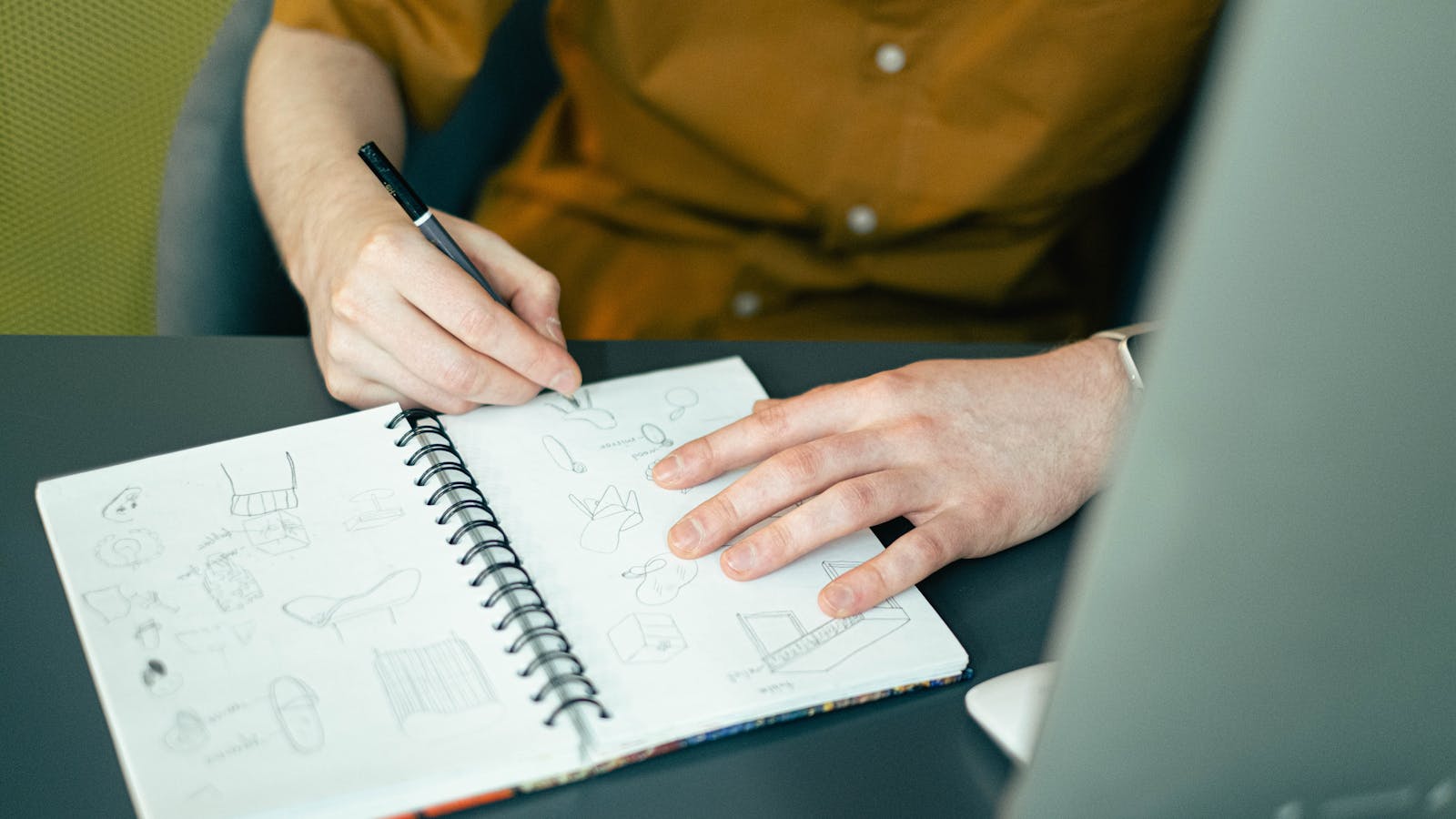Inventor sketching a new product idea in a notebook