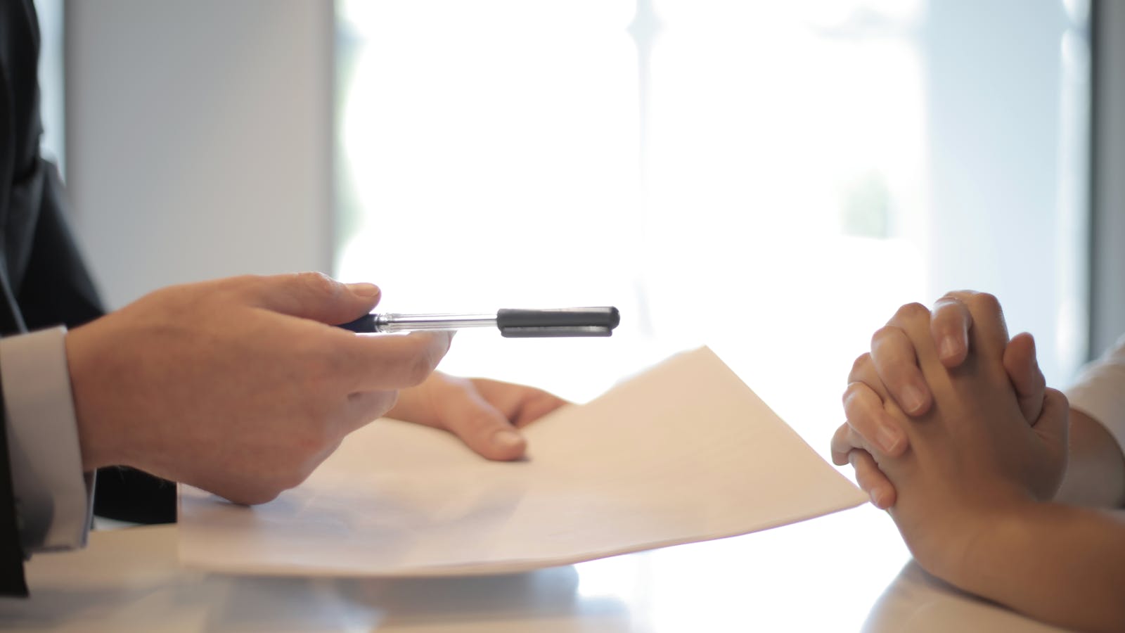 Two people reviewing a licensing agreement across a table